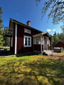 una casa roja y blanca con un patio de césped en Sommardröm, 
