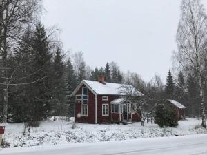 a red house with snow on top of it at Sommardröm in Västra Öskevik