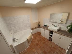 baño grande con bañera y lavamanos en La Maison de la Cloche en Puimoisson