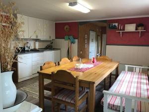 a kitchen with a wooden table and a dining room at Sommardröm in Västra Öskevik