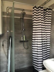 y baño con ducha y cortina en blanco y negro. en Sommardröm, 