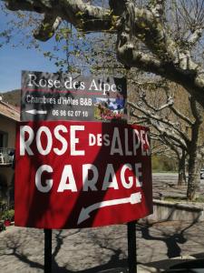 um sinal que lê Rose de Aids Garage em Rose des Alpes em Serres