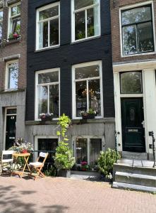 una casa negra con una mesa y sillas delante en Singel Residence en Ámsterdam