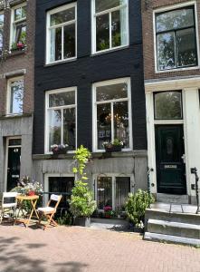 een zwart huis met een tafel en stoelen ervoor bij Singel Residence in Amsterdam