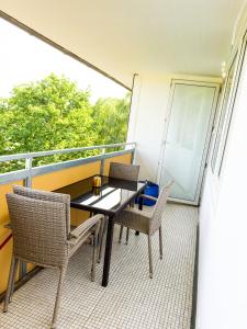 balkon ze stołem i krzesłami oraz oknem w obiekcie Messe-Apartment für 5 Gäste mit Balkon und Lift w Hanowerze
