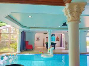a house with a swimming pool with a columns at The Park Pool Villa Pattaya in Pattaya Central