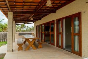 a patio with a table and a bench on a house at Chalé Bistrô Maceió in Camocim