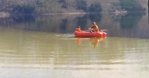dos personas en un bote rojo en un lago en Perlen på solheim I Hyen, en Vereide