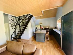 a living room with a staircase and a kitchen at Casa de las Rosas Volcán Arenal in Fortuna