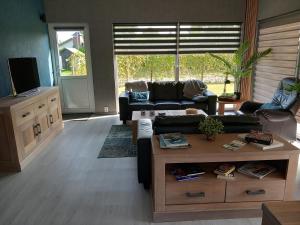 een woonkamer met een bank en een tafel bij Luxe Recreatie Bungalow NO 10 in Scherpenisse
