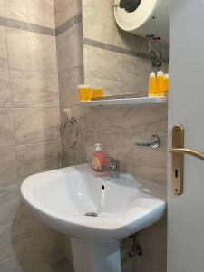 un lavandino in bagno con una bottiglia di sapone di GM Apartments a Tolo
