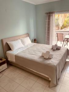 a bedroom with a large bed with two towels on it at GM Apartments in Tolo