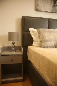 ein Bett mit einem Beistelltisch mit einer Lampe darauf in der Unterkunft Natalie's Condo in Belgrad