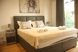 um quarto com uma cama grande e toalhas em Natalie's Condo em Belgrado