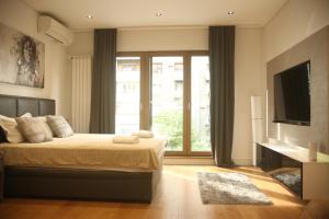 ein Schlafzimmer mit einem Bett und einem großen Fenster in der Unterkunft Natalie's Condo in Belgrad
