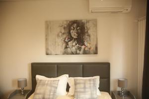 um quarto com uma cama com um quadro por cima em Natalie's Condo em Belgrado