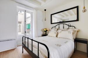 Un dormitorio con una cama en blanco y negro y un espejo en INVALIDES - TOUR EIFFEL, en París