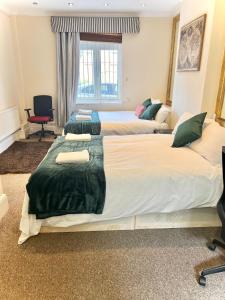 een kamer met drie bedden in een kamer bij Aldgate Holiday Rooms in Londen
