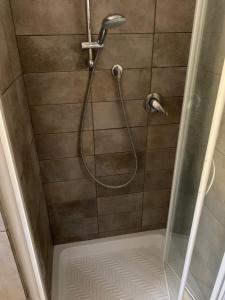 une douche avec un tuyau dans une cabine de douche dans l'établissement Podere Casallorto, à Volterra