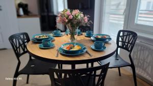 a table with plates of food and a vase of flowers at GoldenApart Apartamenty- 2 sypialnie in Krynica Morska