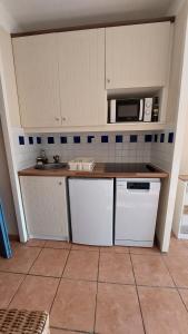 uma cozinha com um lavatório e um micro-ondas em AGREABLE T2 LISIERE DU GOLF LACANAU OCEAN em Lacanau-Océan