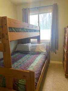 a bunk bed in a room with a window at Gold Coast Family Cottages in Oscoda