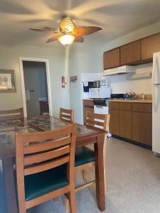 a kitchen with a dining table and a ceiling fan at Gold Coast Family Cottages in Oscoda