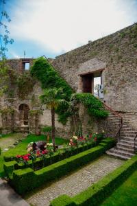 een stenen gebouw met een tuin met bloemen bij Real Scampis Hotel in Elbasan