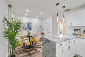 a kitchen with white cabinets and a table and chairs at 2BR 2BA Tampa Home with Hot Tub in Tampa