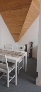 una mesa blanca y sillas en una habitación con techo en Apartmán Na Výsluní en Bělá pod Bezdězem