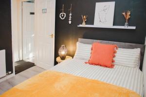 Dormitorio con cama con almohada naranja en Hearty 2-BR House Close to City Centre, en Liverpool