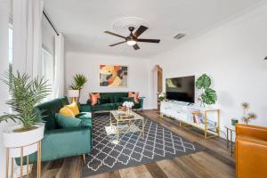 a living room with a green couch and a tv at Glorious House with Backyard, Game Room and Hot Tub in Tampa