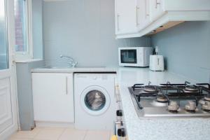 y cocina con fogones y lavadora. en Hearty 2-BR House Close to City Centre, en Liverpool