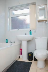 baño con lavabo y aseo y ventana en Hearty 2-BR House Close to City Centre, en Liverpool