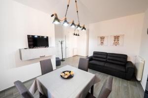 uma sala de estar com uma mesa e um sofá preto em AVA VACATION HOME em Borgetto
