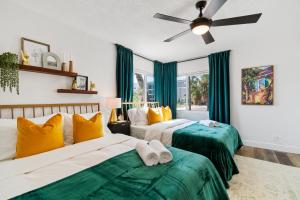 two beds in a room with green and yellow at 2BR 2BA Tampa Home with Hot Tub in Tampa