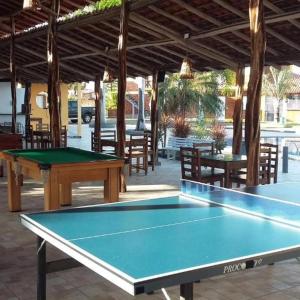 a ping pong table in a pavilion with tables and chairs at Chalé 08 Porto dos Lençóis in Barreirinhas