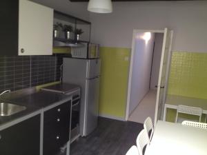 Il comprend une cuisine équipée d'un réfrigérateur, d'une table et de chaises. dans l'établissement LE GRAND ROUGET, à Beaucaire