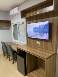 a conference room with a table and a flat screen tv at Hotel Westphal in Pelotas