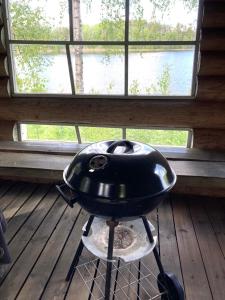 a black grill sitting on a wooden floor in front of a window at Lepikkorinne Raijan Aitta in Mikkeli