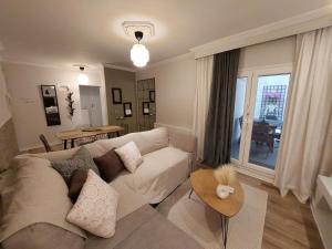 ein Wohnzimmer mit einem weißen Sofa und einem Tisch in der Unterkunft Central Garden Escape in Thessaloniki private parking in Thessaloniki