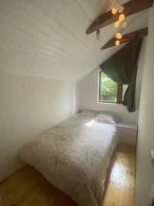 1 dormitorio con 1 cama en una habitación con ventana en Cabana Gavroche en Moara Ungurului