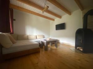 a living room with a white couch and a stove at Cabana Gavroche in Moara Ungurului