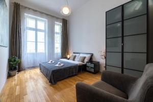 プラハにあるLesser Town Apartment Melnicka by easyBNBのベッドルーム1室(ベッド1台、ソファ、椅子付)