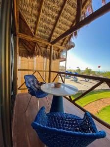 a patio with two chairs and a table on a porch at BobZ Boutique Resort, Suíte 21 in Barra Grande