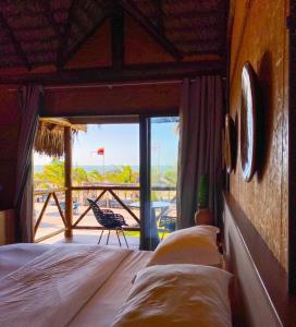 a bedroom with a bed and a balcony with a view at BobZ Boutique Resort, Suíte 21 in Barra Grande