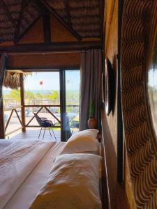 a bedroom with two beds and a view of the ocean at BobZ Boutique Resort, Suíte 21 in Barra Grande