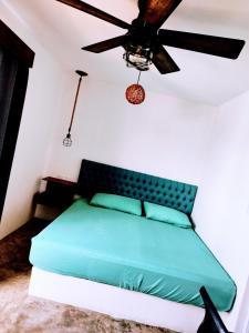 a bed in a room with a ceiling fan at Le Blue Coast in Progreso