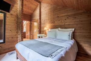 1 dormitorio con 1 cama en una pared de madera en Prado do Xisto - Chalé de madeira a 7km de Braga, en Braga