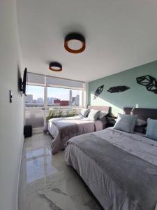sypialnia z 2 łóżkami i dużym oknem w obiekcie Bright APT w/view near Reforma w mieście Meksyk